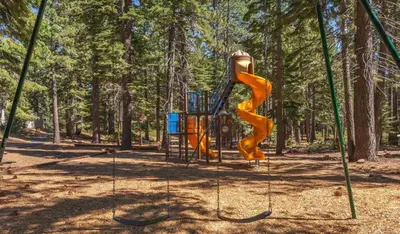a playground in a park with a yellow slide at Tahoe City Retreat Forest Views and Fireplace in Tahoe City