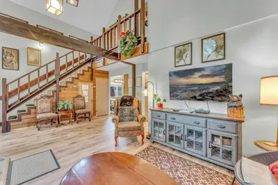 a living room with a staircase and a table at Tahoe City Retreat Forest Views and Fireplace in Tahoe City