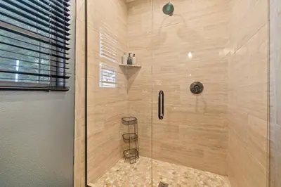 a shower with a glass door in a bathroom at Zen Whisper in the Woods in Groveland