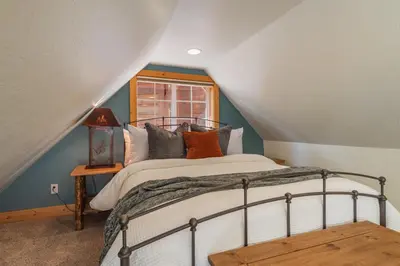 a bedroom with a bed and a window at Home for 10 Private Hot-Tub Close to Ski Private Beach Access w Double Decker pier Book on Mobile for Promo Price in Carnelian Bay