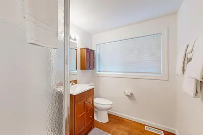 a white bathroom with a toilet and a window at Lipan Lodge in South Lake Tahoe