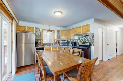 a kitchen with a wooden table and a refrigerator at Lipan Lodge in South Lake Tahoe