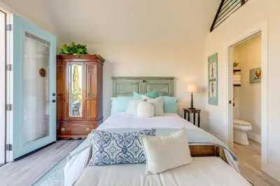 a bedroom with a bed with blue and white pillows at Steps to Sutter Creek Chic Wine Country Cottage in Sutter Creek