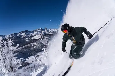 a person is skiing down a snow covered mountain at Summit #269 - 2 Bedrm 2 Bathrm Condo - Walk To Eagle Lodge Lifts in Mammoth Lakes