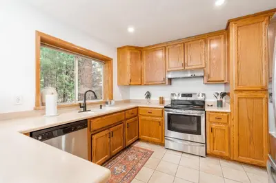 a kitchen with wooden cabinets and stainless steel appliances at Lovely Home in Pollock Pines with Hot Tub in Pollock Pines