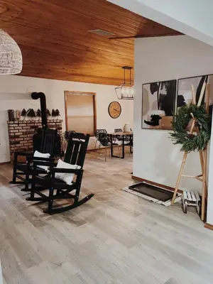 a living room with rocking chairs and a fireplace at Lovely Home in Pollock Pines with Hot Tub in Pollock Pines