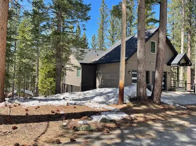 a house in the woods with snow and trees at Grandview Manor - Luxury - Hot tub - Stylish in South Lake Tahoe