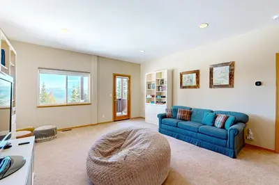 a living room with a blue couch and a window at Skislope Serenity in Truckee