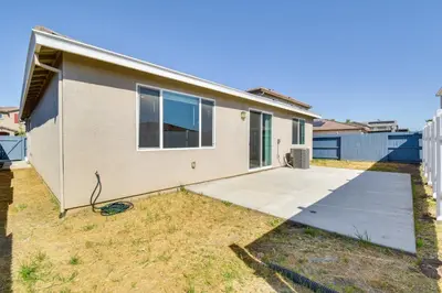 a house with a concrete driveway in front of it at WFH-Friendly Getaway with Yard in Manteca! in Manteca