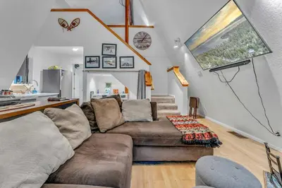 a living room with a couch and a table at White Fir Chalet Dog Friendly Cabin in the Woods in Soda Springs