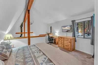 a bedroom with a bed and a desk and a television at White Fir Chalet Dog Friendly Cabin in the Woods in Soda Springs