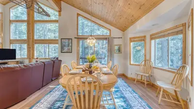 a dining room with a table and chairs and windows at Hansel by AvantStay Pool Table 5mins to Skiing in Truckee
