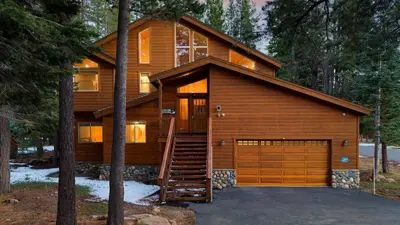 a log house with a garage in the woods at Hansel by AvantStay Pool Table 5mins to Skiing in Truckee