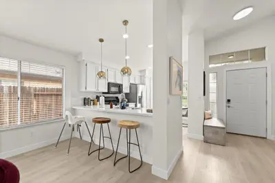 a kitchen with a counter and stools in a room at Recently Upgraded House with King Suite, quiet NBHD, Fast Wifi, and Yard in Elk Grove