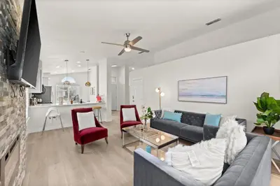 a living room with a gray couch and red chairs at Recently Upgraded House with King Suite, quiet NBHD, Fast Wifi, and Yard in Elk Grove