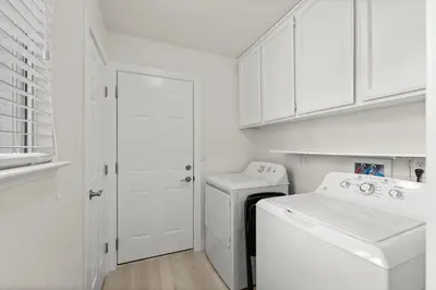 a white laundry room with a washer and dryer at Recently Upgraded House with King Suite, quiet NBHD, Fast Wifi, and Yard in Elk Grove