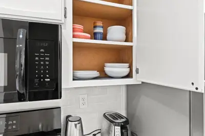a kitchen with a cupboard with dishes in it at Recently Upgraded House with King Suite, quiet NBHD, Fast Wifi, and Yard in Elk Grove