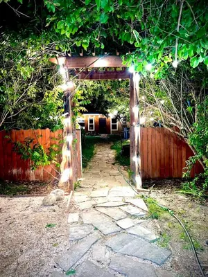 an archway with lights in a yard with a fence at 2 Private Bedroom Suites with Hot Tub in Sacramento