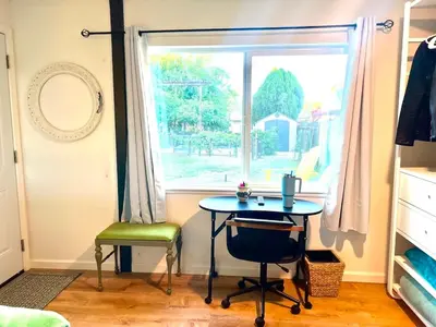 a table and a chair in a room with a window at 2 Private Bedroom Suites with Hot Tub in Sacramento