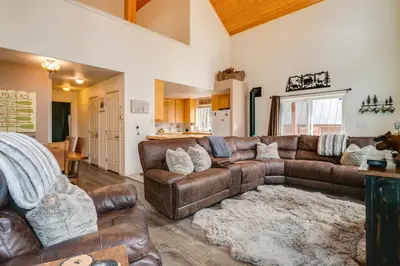 a living room with a brown leather couch at Snowshoe and Sled On-Site! Soda Springs Cabin in Soda Springs