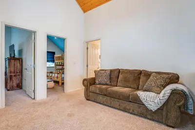a living room with a brown couch in a room at Snowshoe and Sled On-Site! Soda Springs Cabin in Soda Springs