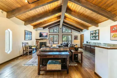 a large living room with wooden ceilings and a table at Northstar Family Retreat on Shuttle Line with Deck in Truckee