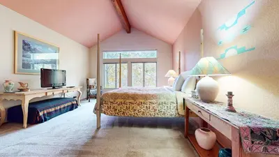 a bedroom with a bed and a tv and a window at Snowcreek IV #545 condo in Mammoth Lakes