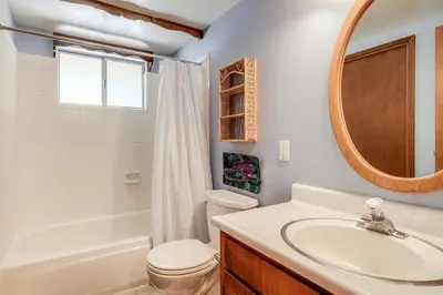 a bathroom with a sink and a toilet and a mirror at Arnold Chalet Near Town and Calaveras Big Trees! in Arnold