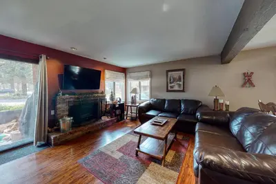 a living room with a leather couch and a fireplace at Wildflower 47 in Mammoth Lakes