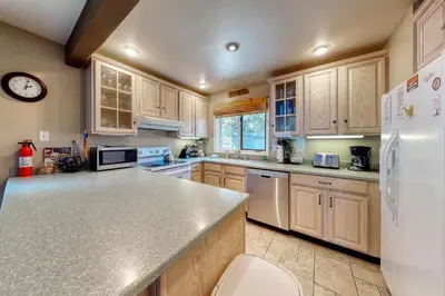a kitchen with wooden cabinets and a white refrigerator at Wildflower 47 in Mammoth Lakes