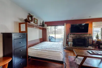 a bedroom with a bed and a tv and a fireplace at Wildflower 47 in Mammoth Lakes