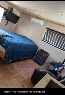 a bedroom with a blue bed and a couch at Charming Casita all too yourself near Midtown, Train and Freeway in Sacramento