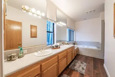 a bathroom with two sinks and a large mirror at Granite Ridge Getaway Chill Deck Vibes AC in Shaver Lake