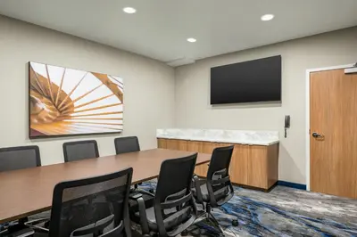a conference room with a table and chairs and a flat screen tv at Fairfield Inn & Suites Livermore in Livermore