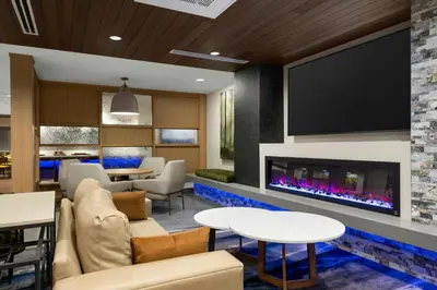 a lobby with a fireplace and a tv at Fairfield Inn & Suites Livermore in Livermore