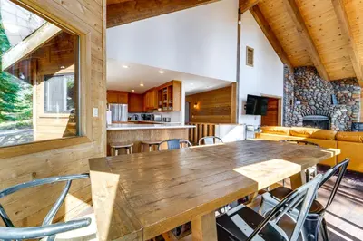 a dining room and kitchen with a wooden table and chairs at 6 Mi to Ski Slopes! Family Tahoe Cabin with 3 Decks in Tahoe Vista
