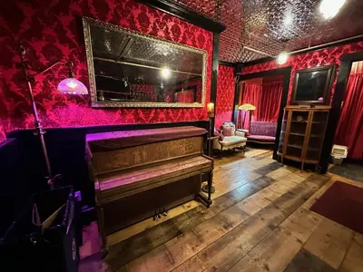an old piano in a room with red walls at West River House in Truckee