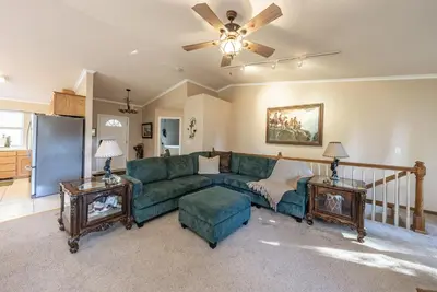 a living room with a green couch and two tables at Eagle Retreat Mountain Escape New With AC in Shaver Lake