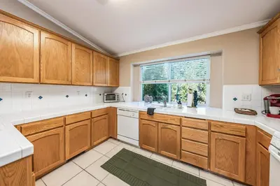 a kitchen with wooden cabinets and a window at Eagle Retreat Mountain Escape New With AC in Shaver Lake