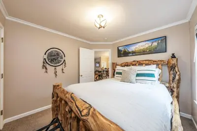 a bedroom with a large bed with a wooden headboard at Eagle Retreat Mountain Escape New With AC in Shaver Lake