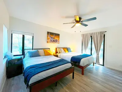 a bedroom with two beds and a ceiling fan at Modern Yosemite Cabin, 15min Bass Lake, Sleeps 8 in Oakhurst