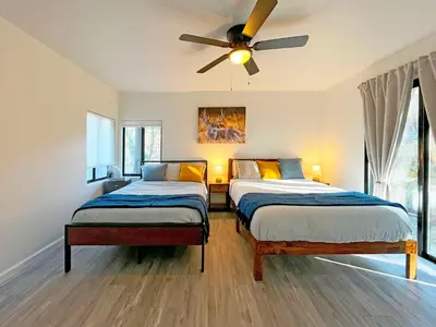 a bedroom with two beds and a ceiling fan at Modern Yosemite Cabin, 15min Bass Lake, Sleeps 8 in Oakhurst