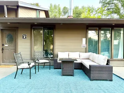 a patio with a couch and chairs on a house at Modern Yosemite Cabin, 15min Bass Lake, Sleeps 8 in Oakhurst