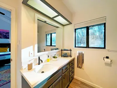 a bathroom with a sink and a large mirror at Modern Yosemite Cabin, 15min Bass Lake, Sleeps 8 in Oakhurst