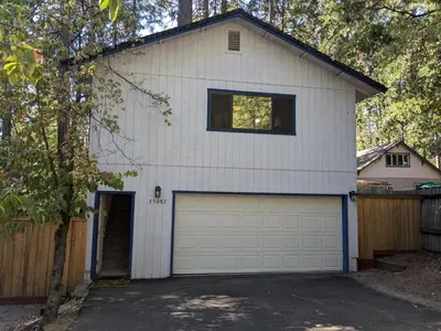 a white house with a garage at Bulldog Den in Twain Harte