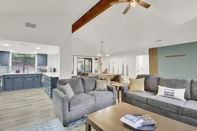 a living room with two couches and a kitchen at Yosemite Forest Villa in Oakhurst
