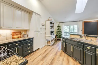 a large kitchen with a sink and a tv at Forest-View Retreat Grill and Fireplace in Sonora in Sonora