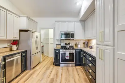 a kitchen with white cabinets and black appliances at Forest-View Retreat Grill and Fireplace in Sonora in Sonora