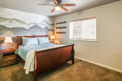 a bedroom with a bed with a painting on the wall at Forest-View Retreat Grill and Fireplace in Sonora in Sonora