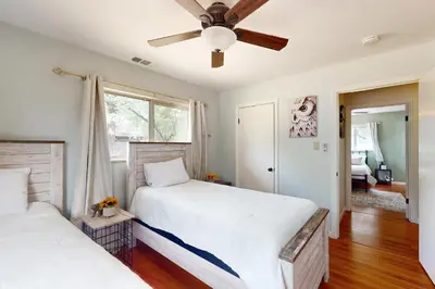 two beds in a bedroom with a ceiling fan at Uhre Family Retreat in Oakhurst